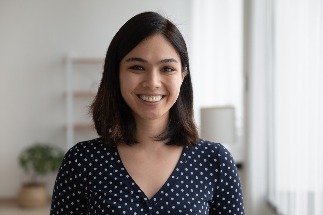 Profile picture of smiling asian woman posing indoors